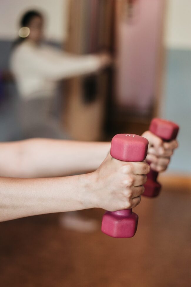 Bottle of Kombucha Bangkok next to dumbbells and a yoga mat, highlighting post-workout hydration.