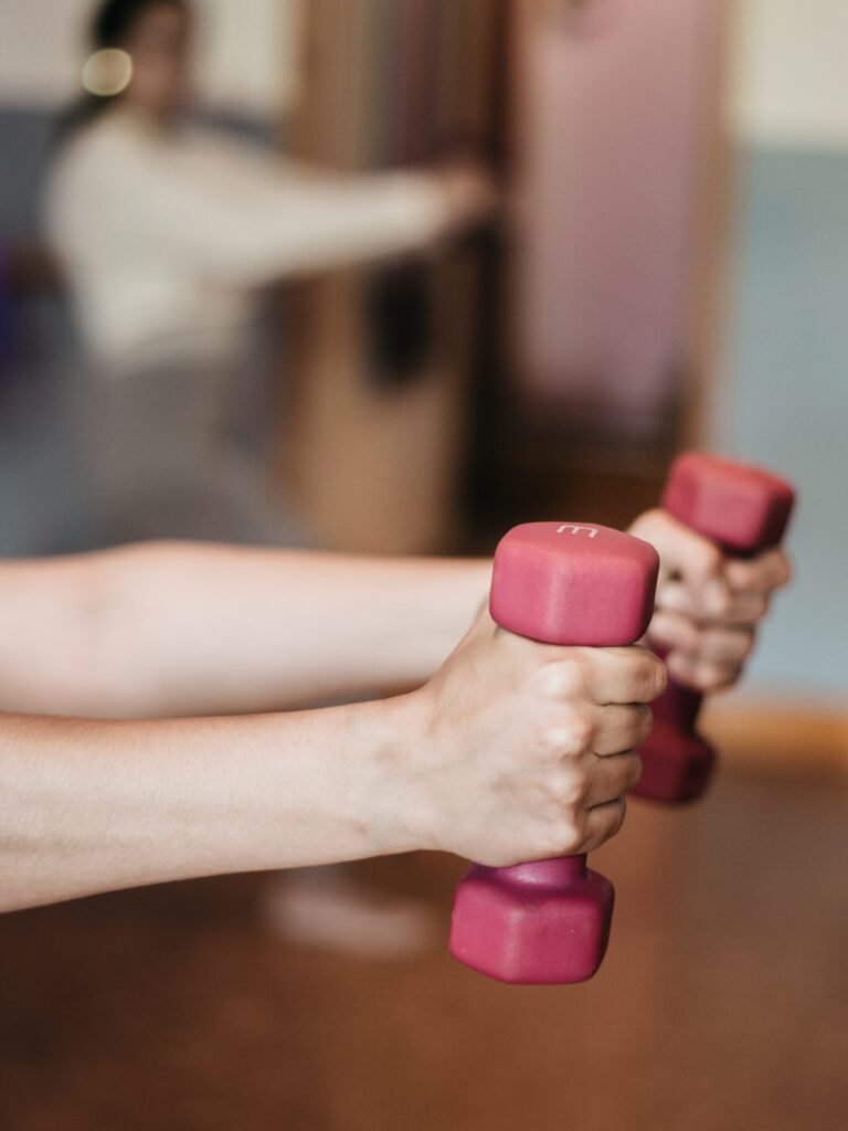 Bottle of Kombucha Bangkok next to dumbbells and a yoga mat, highlighting post-workout hydration.